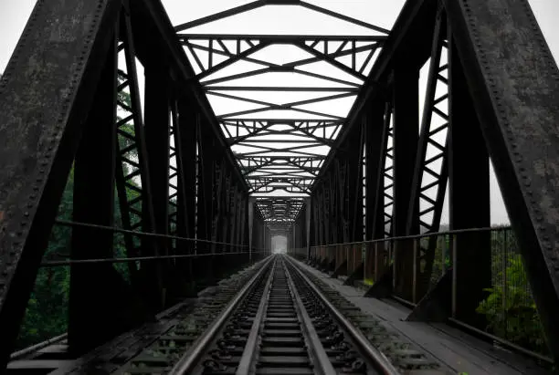 Photo of Black steel railway train bridge perspective scenery in rural area