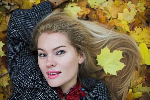 Beautiful young woman and autumn background with color leaves stock photo