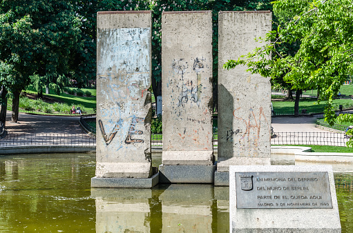 Madrid, Spain - May 8, 2021: Berlin Park in Madrid, Spain. View of a fountain with original remains of the Berlin Wall with its original paintings