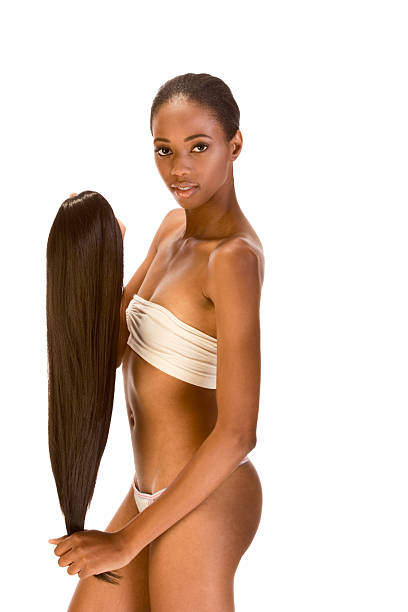 Afro-American model in lingerie holding female wig Beautiful young ethnic brunet woman with Slicked Back Hair wearing white tube-top and panties stretch long dark hair extensions, preparing to put it on black woman hair extensions stock pictures, royalty-free photos & images