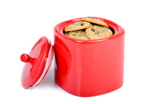 A batch of fresh chocolate chip cookies in a bright red Jar.