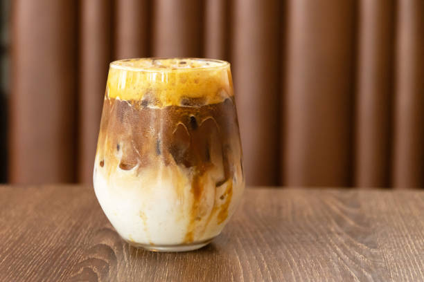 glass of iced caramel macchiato on wooden table on background - caramel latté coffee cafe macchiato imagens e fotografias de stock