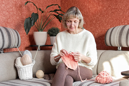 Happy and relaxed female people enjoying time indoor on the sofa. Knit job