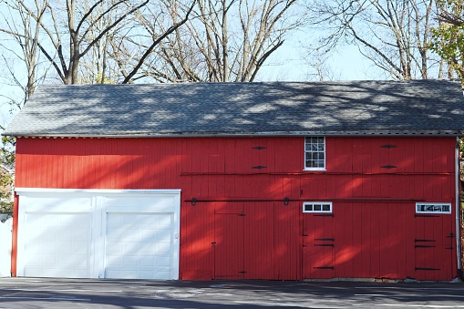A red wooden building with two white garage doors.