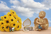 Beautiful shot of flowers and an angel figurine with butterflies and jewelry box