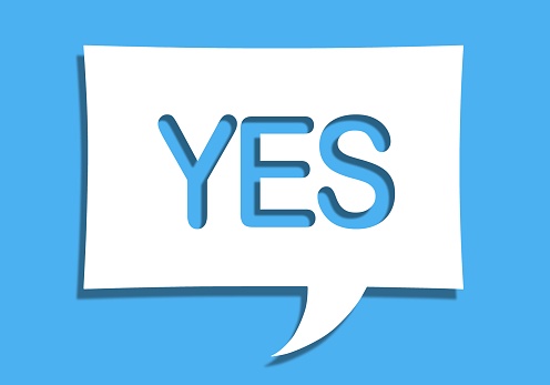 An illustration of a white paper speech bubble with the word yes on it isolated on blue background