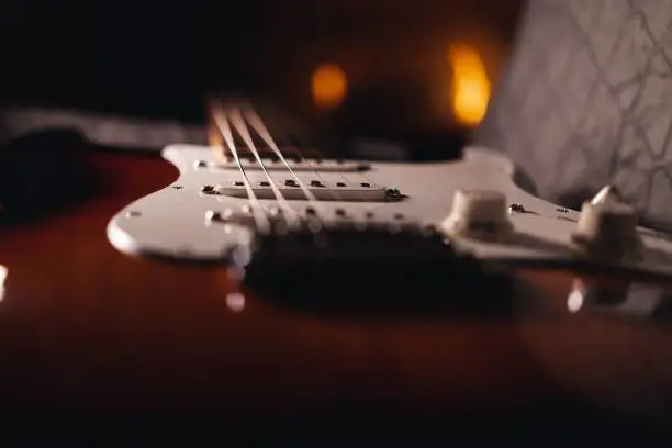 A selective focus of the strings of Stratocaster electric guitar