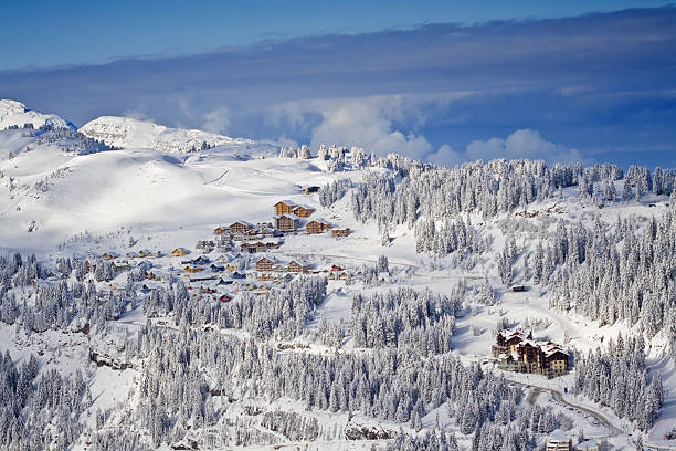 snow covered mountain side with buildings stock photo