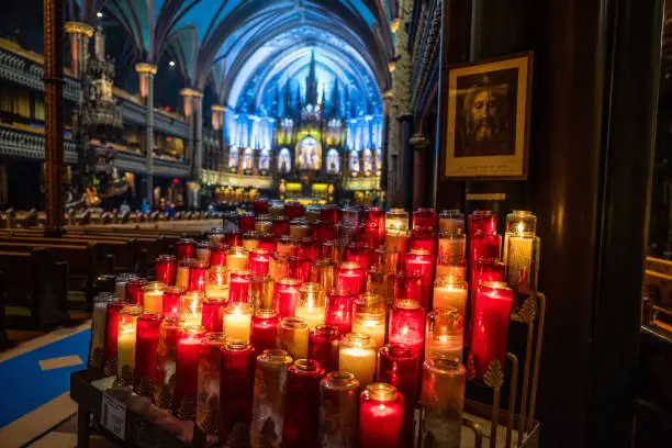 Photo of Bunch of bright candles burning in Notre-Dame Basilica in Montreal, Canada