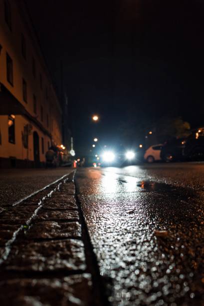 istock Rainy street at night with a passing car 1467255143