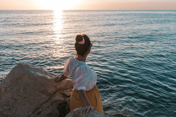 istock Caucasian female standing in between two big rocks at the coast 1467255870
