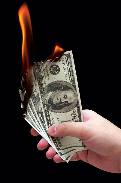 burn Burning dollars in a hand Aflame stock pictures, royalty-free photos & images