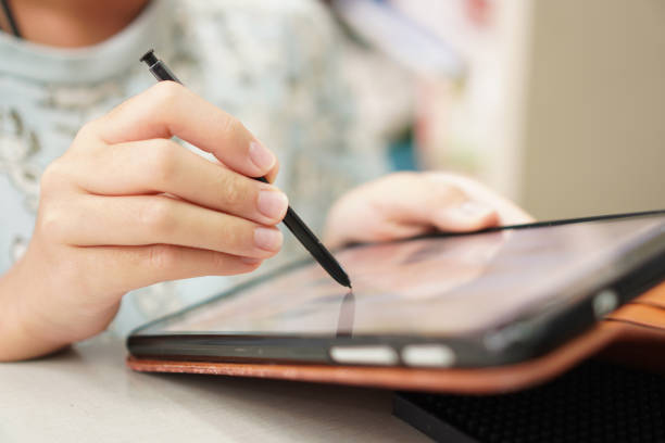 istock Picture shows a little boy using a touch screen tablet device to do homework at home. 1467259352