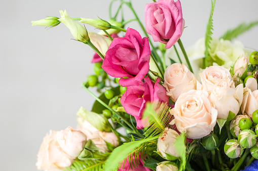 A closeup of beautiful fresh with white roses and pink lisianthus in a bouquet