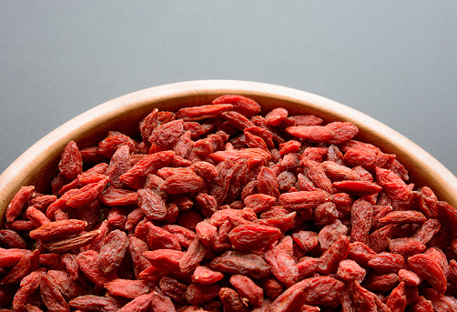 A wooden bowl full of dried Goji berries for a healthy diet
