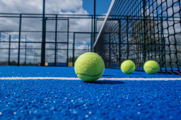 foco seletivo, quatro bolas de tênis de remo em uma quadra de tênis de remo azul perto da rede - traditional sport fotos - fotografias e filmes do acervo