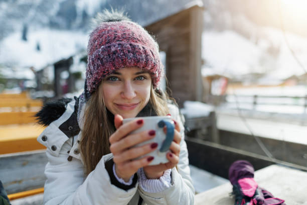 teenage girl enjoying hot tea in an outdoors restaurant on a sunny winter day. - apres ski snow winter european alps imagens e fotografias de stock