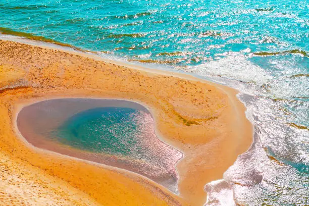 Natural pool of water on the beach . Idyllic tropical coast with golden sand