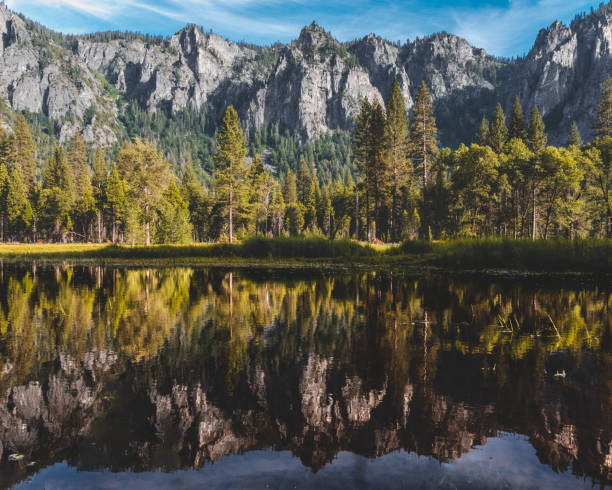 istock Reflection of forest trees on lake water with cliffs on background 1467263299