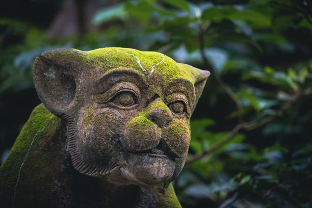 Traditional demon sculpture made of stone in the jungle of the Bali island, Indonesia. Seen at the Monkey Forest in Ubud.