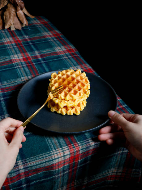 istock View of human hands eating Belgian waffles on a striped carpet 1467264363