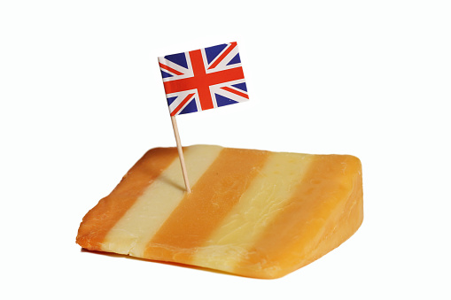 A closeup of 5 layered English cheese with British flag isolated on white background.