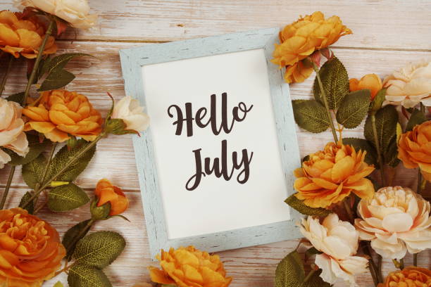 istock Hello July typography text with flower decoation on wooden background 1467267488