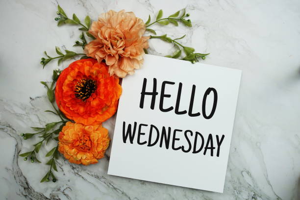 istock Hello Wednesday text with orange flower bouquet on marble background 1467267954