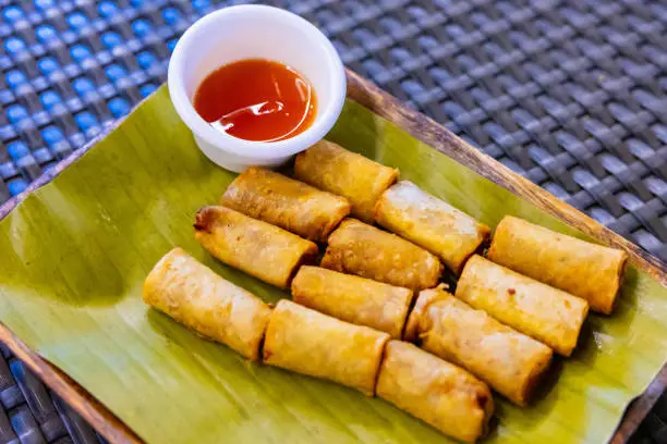 Fried lumpia, also known as Filipino spring rolls, are crispy pastry rolls filled with vegetables, meat, and sometimes shrimp, and served with a dipping sauce.