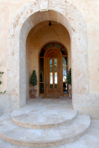 Custom stone arch and stair entrance adorn a luxury home.