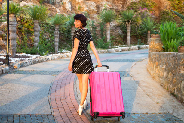 솔로 여행, 여자는 바퀴에 큰 여행 가방을 들고 - individual event 뉴스 사진 이미지