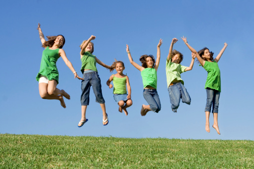 group of hapy smiling kids or children jumping at summer camp