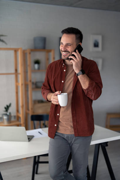 istock Cheerful modern man freelancer on cell phone conversation 1467275385