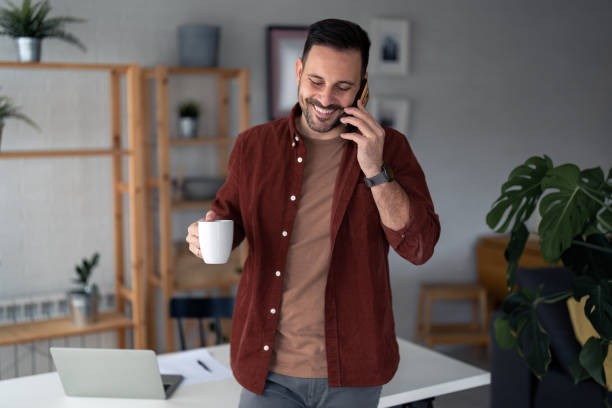istock Handsome good-looking man freelance worker on satisfying mobile phone conversation 1467275403