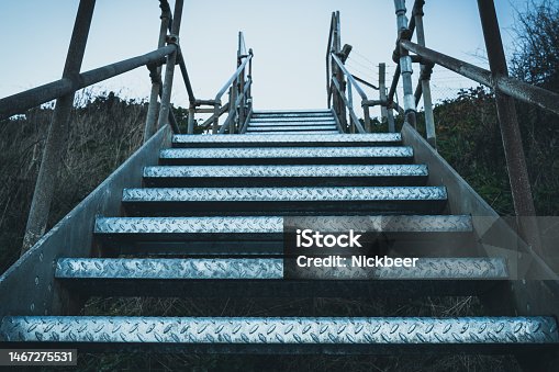 istock Abstract view looking up in a metal staircase located on a cliff edge. 1467275531