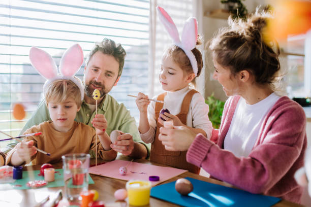 istock Happy family with little kids decorating easter eggs. 1467277284