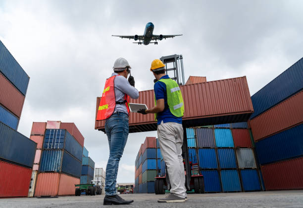 trabajador industrial trabaja con un compañero de trabajo en el puerto de contenedores de envío en el extranjero. gestión logística de la cadena de suministro y concepto de exportación internacional de mercancías. - industrial ship dock worker engineer harbor fotografías e imágenes de stock