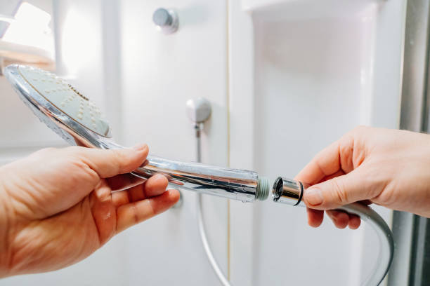 istock men's hands screw the shower head onto a new hose. 1467280801