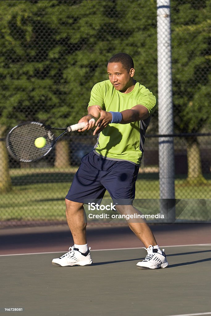 Homem na quadra de tênis sobre a alcançar um Forehand - Foto de stock de Tênis - Esporte de Raquete royalty-free