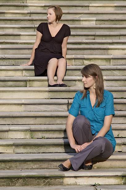 young girls sitting on stairs stock photo