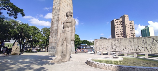 Image of the square in the city center of Curitiba. In the image you can see the mural of Poty Lazarotto that shows the independence of the state of Paraná in 19th of Dezember 1853 and a sculpture of a naked man done by Erbo Stenzel and Humberto Cozzo in 1953. Image taken in December 2021 in Curitiba.