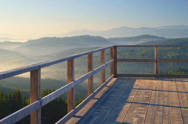 Early morning view from the terrace on Carpathian mountain range. Sunbeams falling on the balcony, blue mountain peaks in the background.