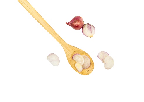 Onion in a wooden spoon isolated