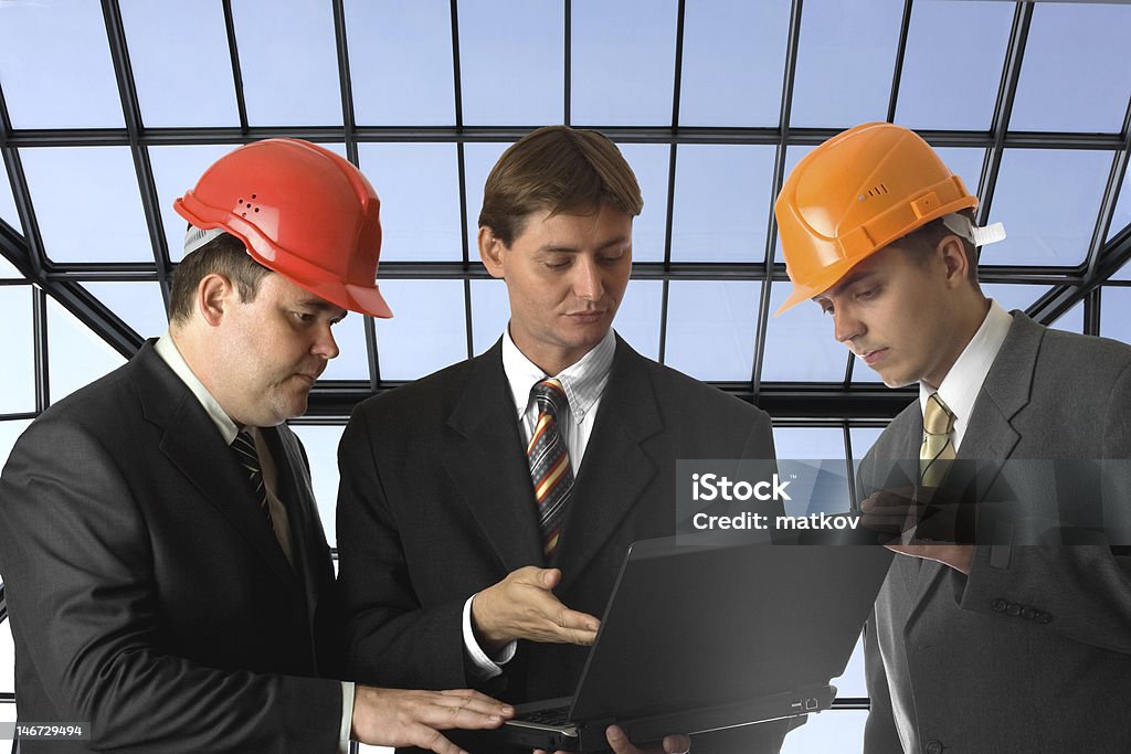 Chefe e dois construtores com computador portátil - Royalty-free Adulto Foto de stock