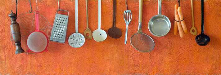 Vintage kitchen utensils,food and drink and kitchen concept, nostalgic items hanging on orange  background,panoramic,free copy space