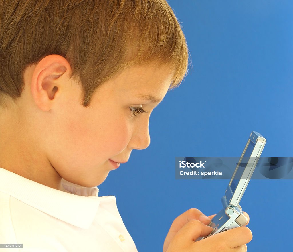 boy with video game young boy playing a handheld video game Activity Stock Photo