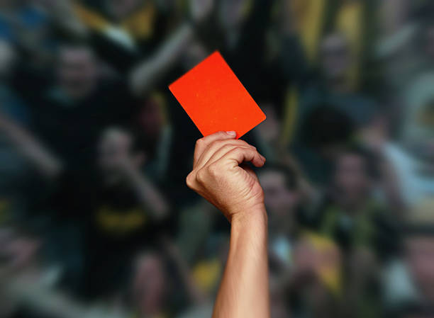 istock A hand holding a red card up in front of a blurred crowd 146730722
