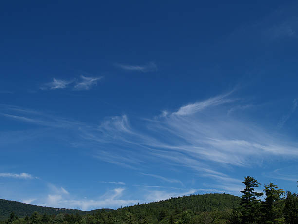 cirrus clouds over green mountain tops stock photo