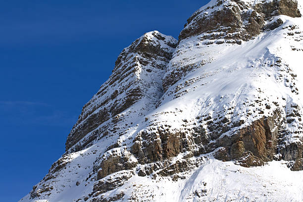 snow covered cliff face stock photo