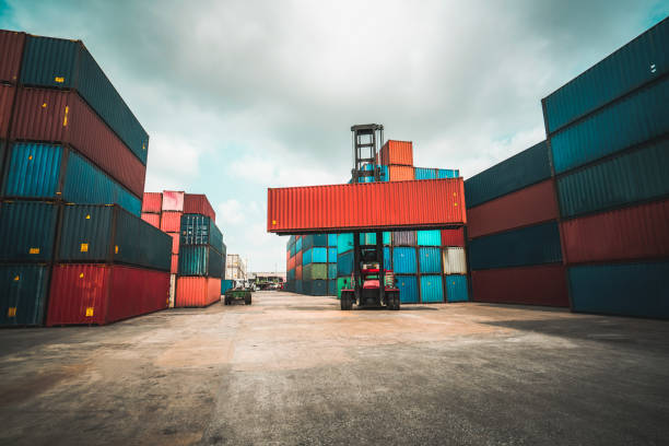 Cargo container for overseas shipping in shipyard with heavy machine . Logistics supply chain management and international goods export concept .